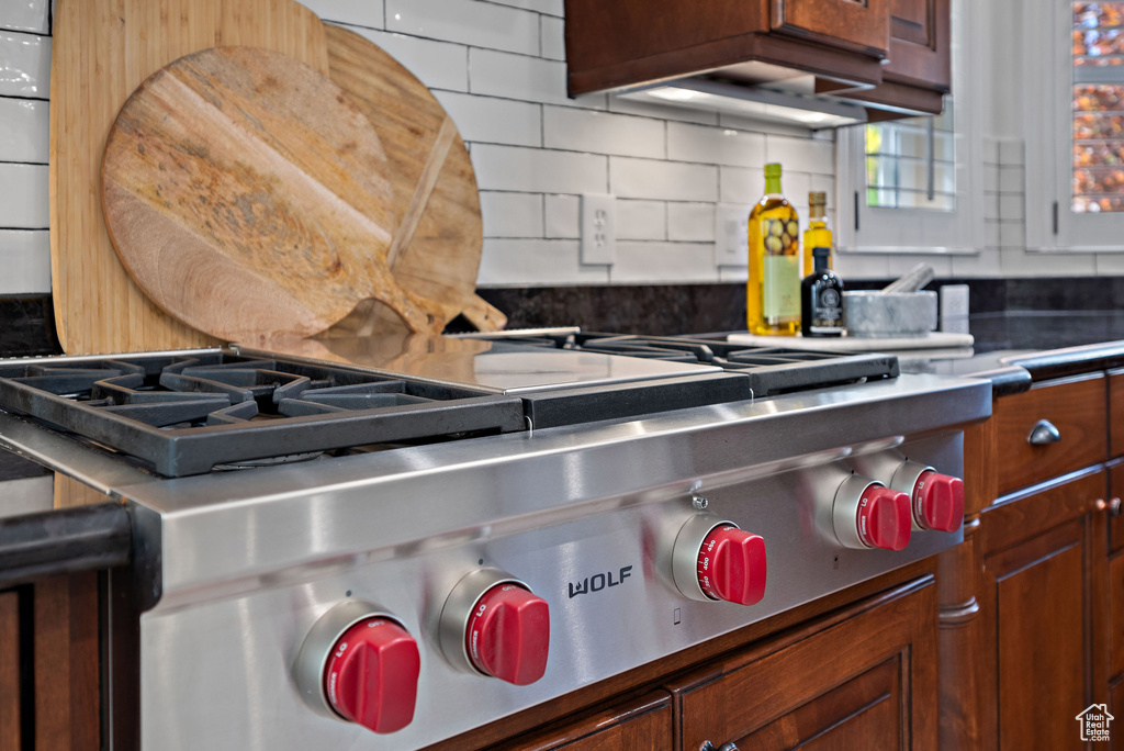 Kitchen with tasteful backsplash and stainless steel gas cooktop
