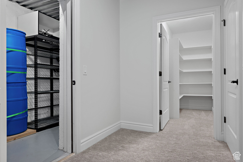 Corridor featuring carpet floors and baseboards