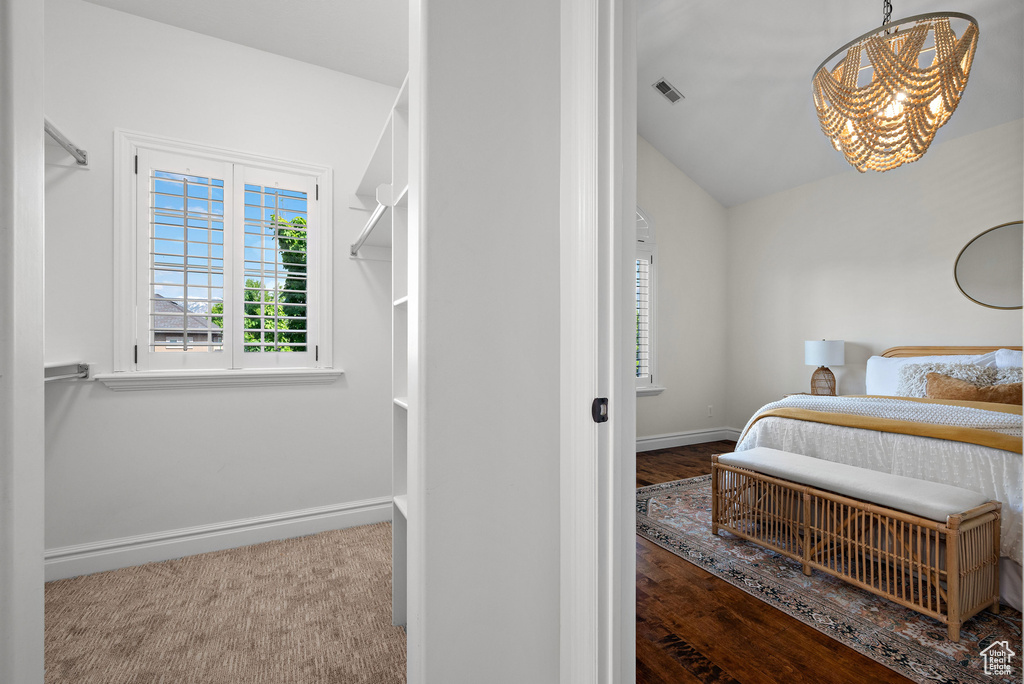 Bedroom featuring a chandelier, multiple windows, baseboards, and lofted ceiling