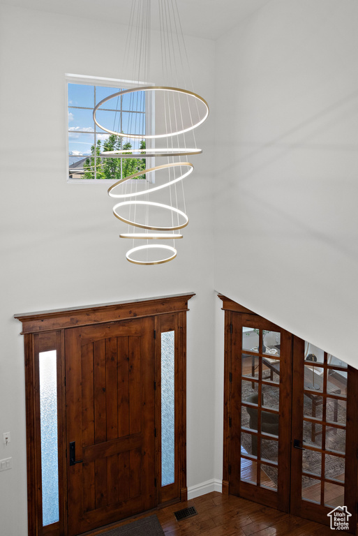 Foyer with a chandelier, wood finished floors, and baseboards