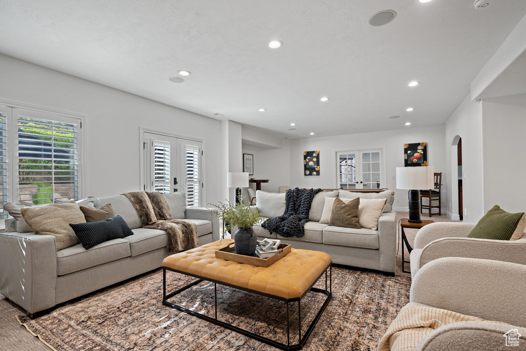 Living area with arched walkways, french doors, and recessed lighting