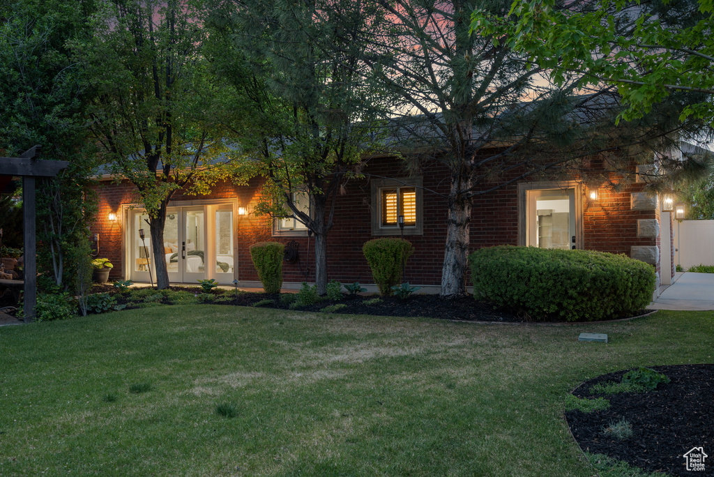 View of front of house featuring a front lawn and brick siding