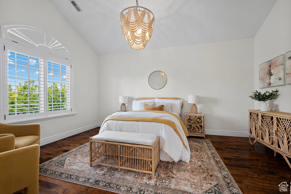 Bedroom with a chandelier, baseboards, vaulted ceiling, and wood finished floors