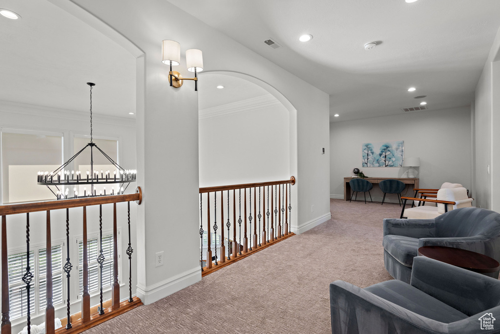 Corridor with a chandelier, recessed lighting, crown molding, carpet flooring, and baseboards