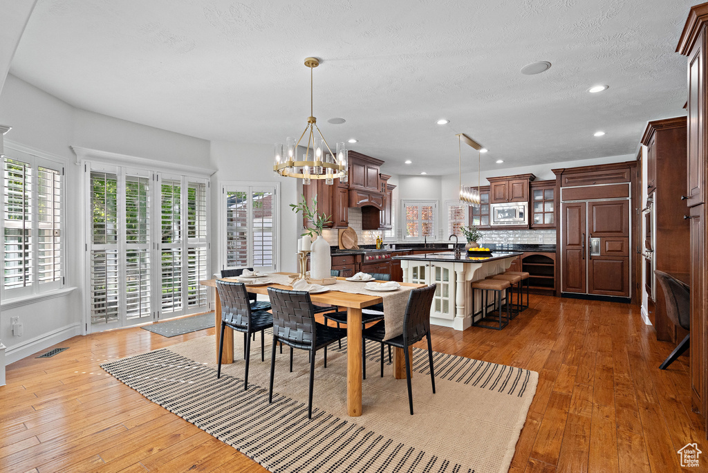 Dining space featuring plenty of natural light, a chandelier, light wood-type flooring, recessed lighting, and baseboards