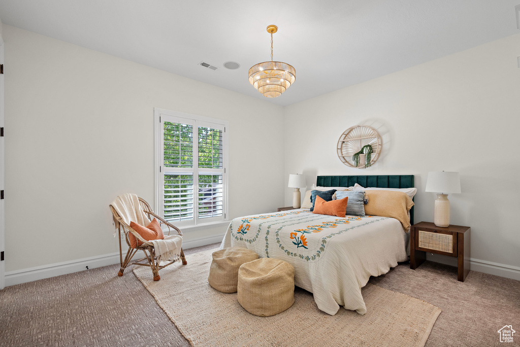 Bedroom with carpet floors, baseboards, and a chandelier