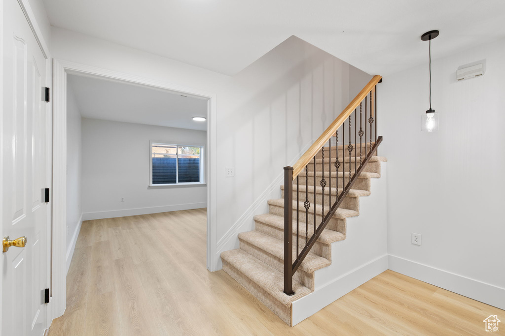Staircase with wood finished floors and baseboards