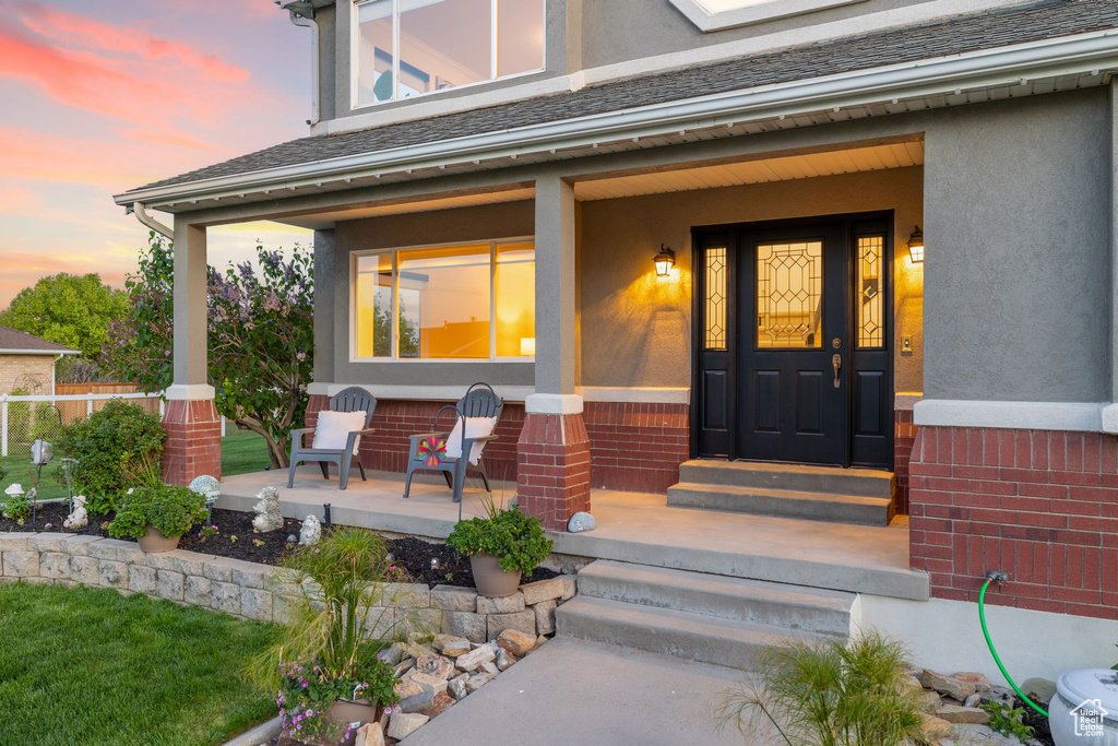 Doorway to property featuring a porch and stucco siding
