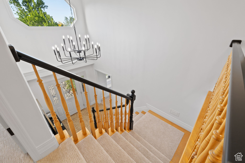 Staircase featuring a chandelier, baseboards, and wood finished floors