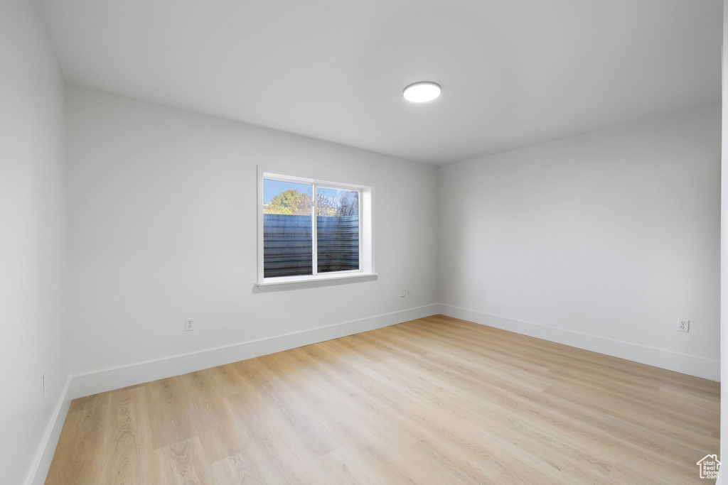Spare room featuring baseboards and light wood-style flooring