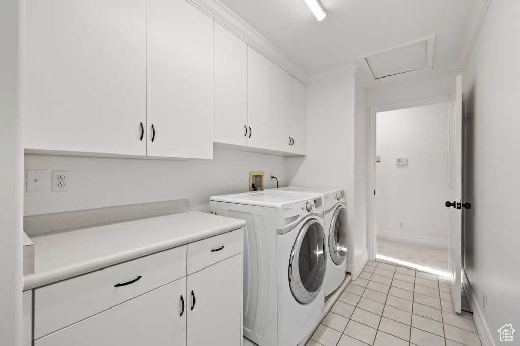 Laundry room featuring cabinet space, independent washer and dryer, light tile patterned floors, baseboards, and ornamental molding