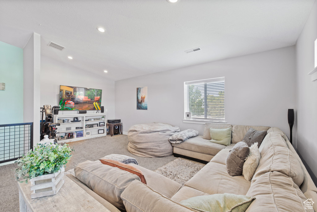 Living room featuring carpet, recessed lighting, and lofted ceiling