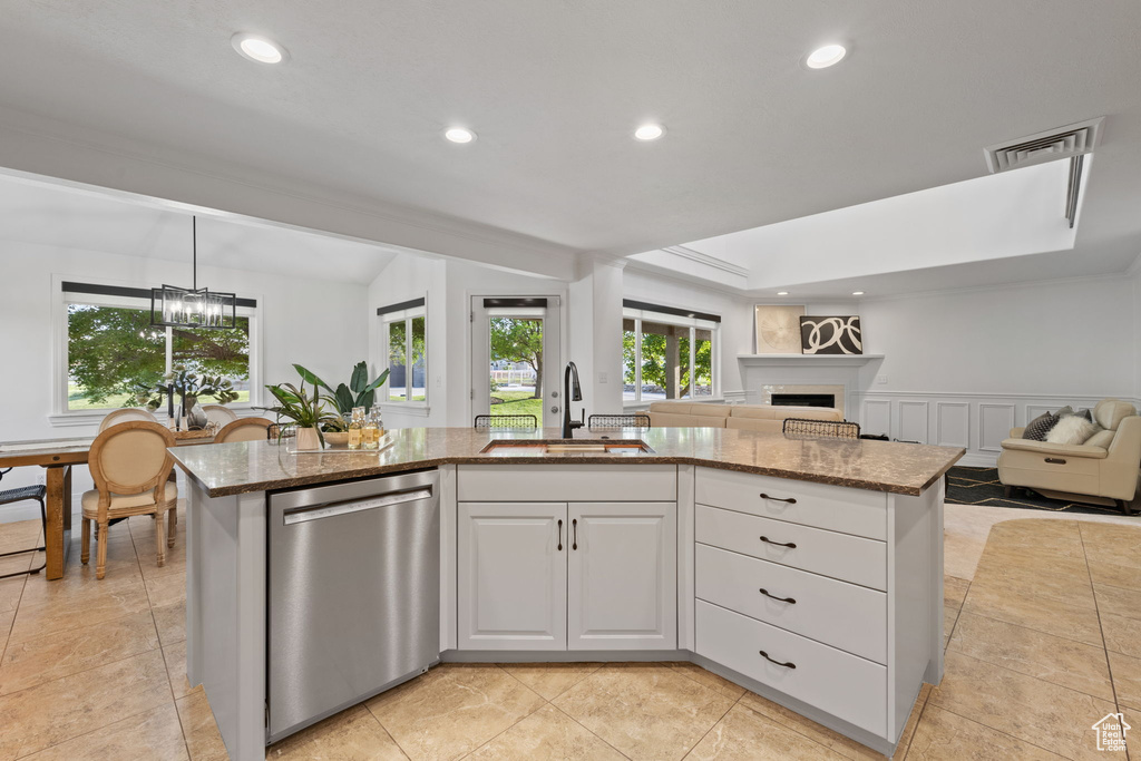 Kitchen with a sink, dishwasher, open floor plan, recessed lighting, and stone counters