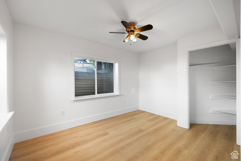 Unfurnished bedroom with light wood finished floors, baseboards, a closet, and ceiling fan
