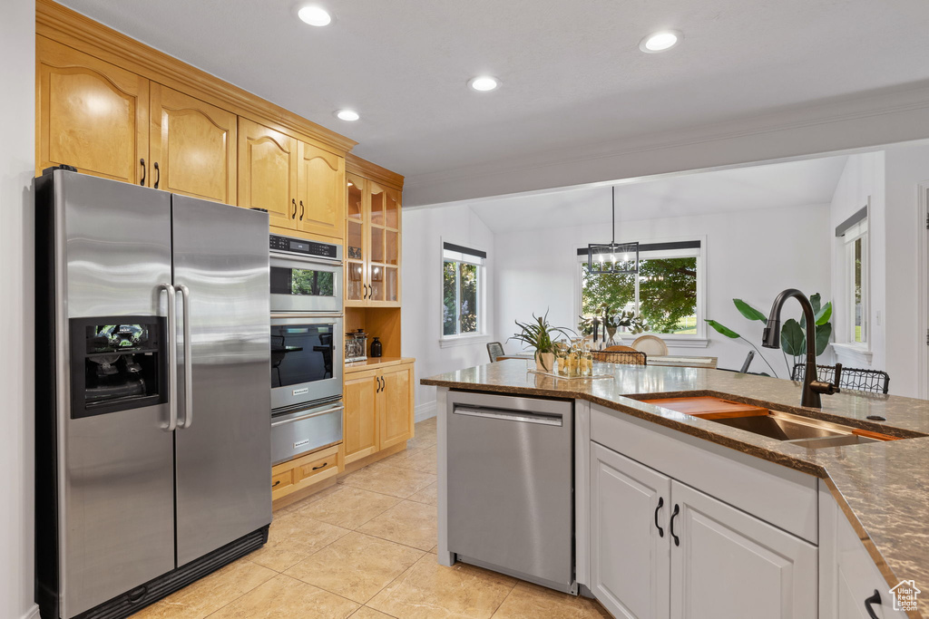Kitchen with stainless steel appliances, a sink, a warming drawer, dark stone counters, and recessed lighting