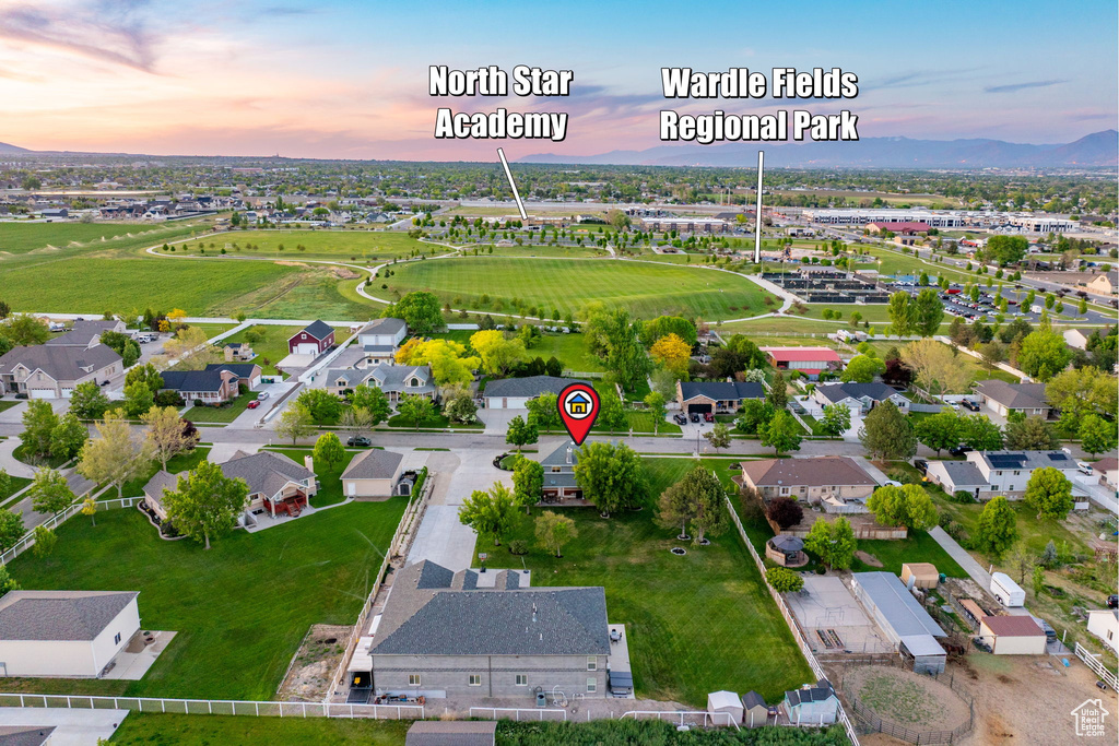 Aerial view of property and surrounding area with nearby suburban area and a mountainous background