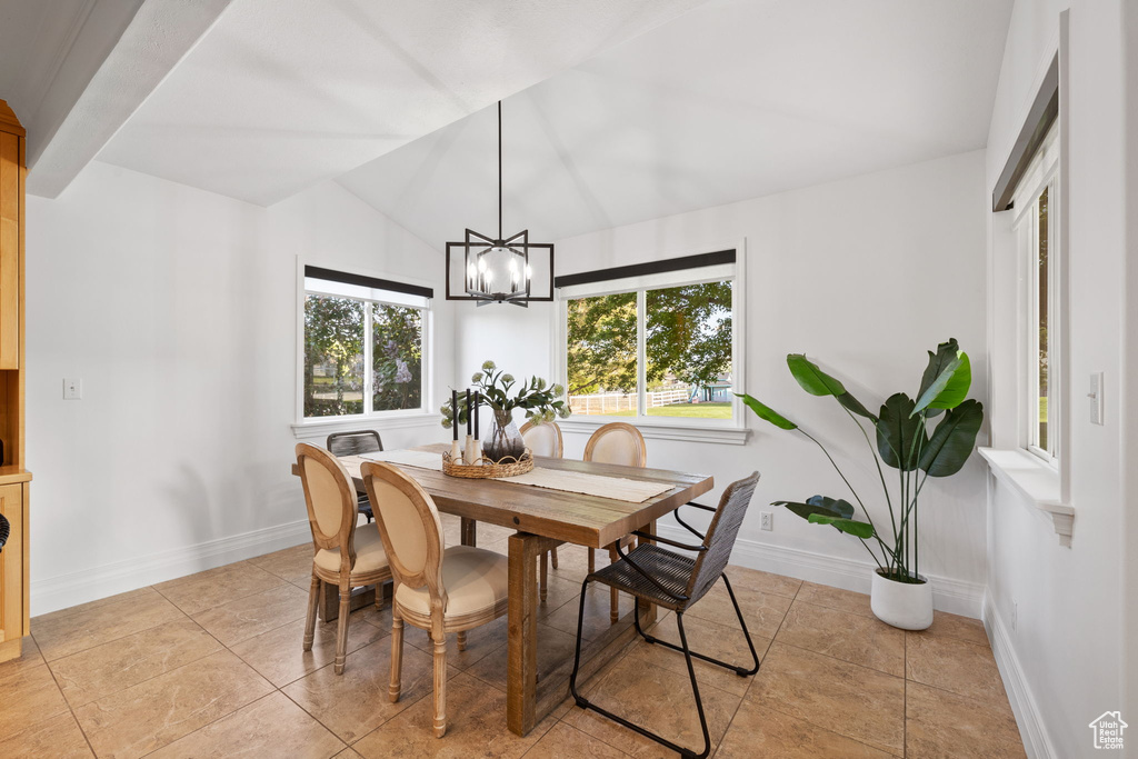 Dining room with lofted ceiling, baseboards, a chandelier, and light tile patterned floors