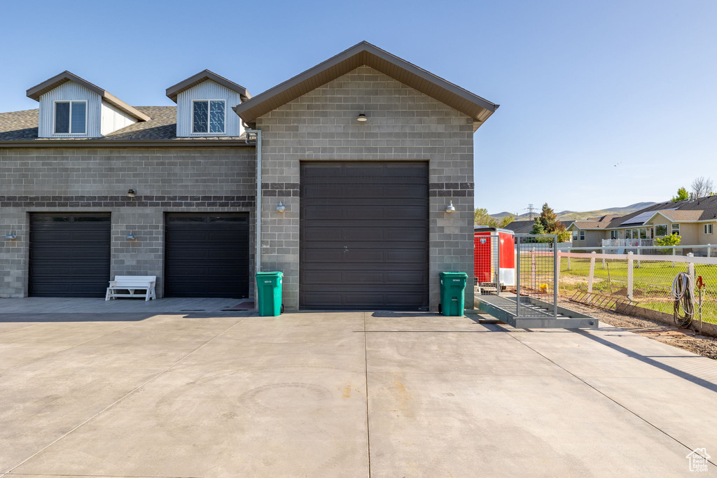 Garage featuring driveway and fence