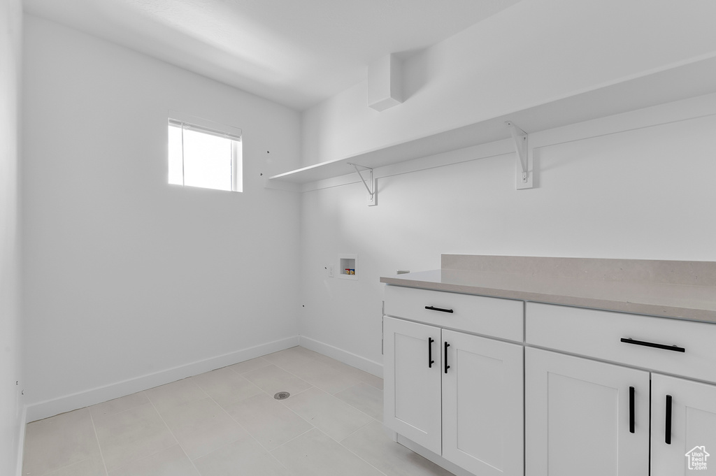 Washroom featuring hookup for a washing machine, baseboards, and cabinet space