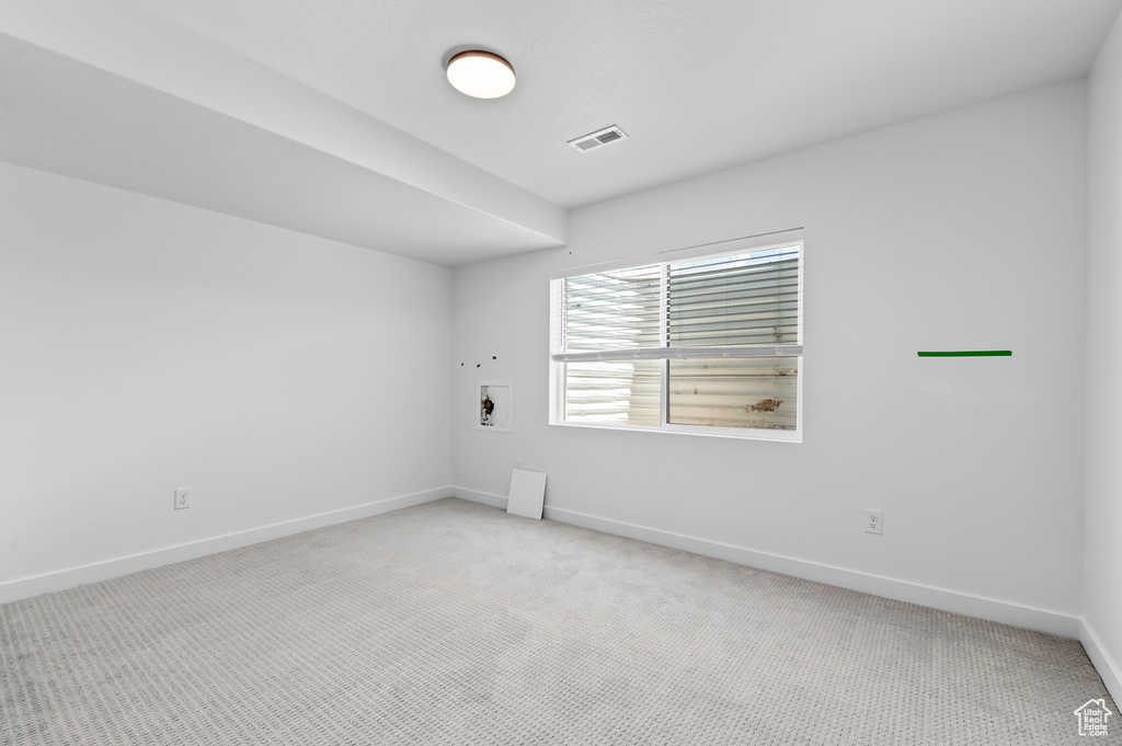 Empty room with light colored carpet and baseboards