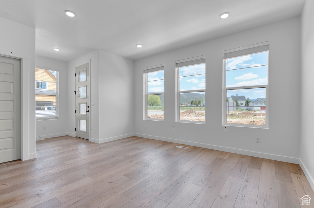 Unfurnished room featuring baseboards, recessed lighting, and light wood finished floors