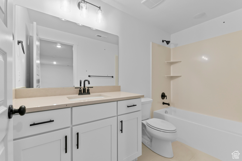 Bathroom with toilet, tile patterned flooring, vanity, and tub / shower combination