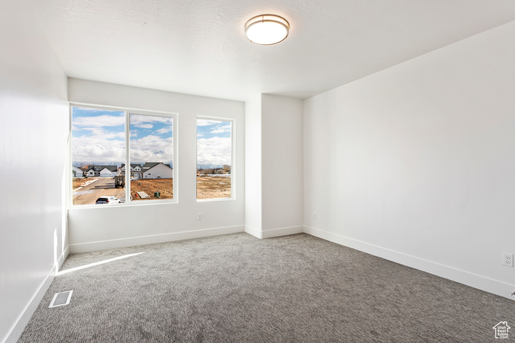 Unfurnished room featuring carpet floors and baseboards
