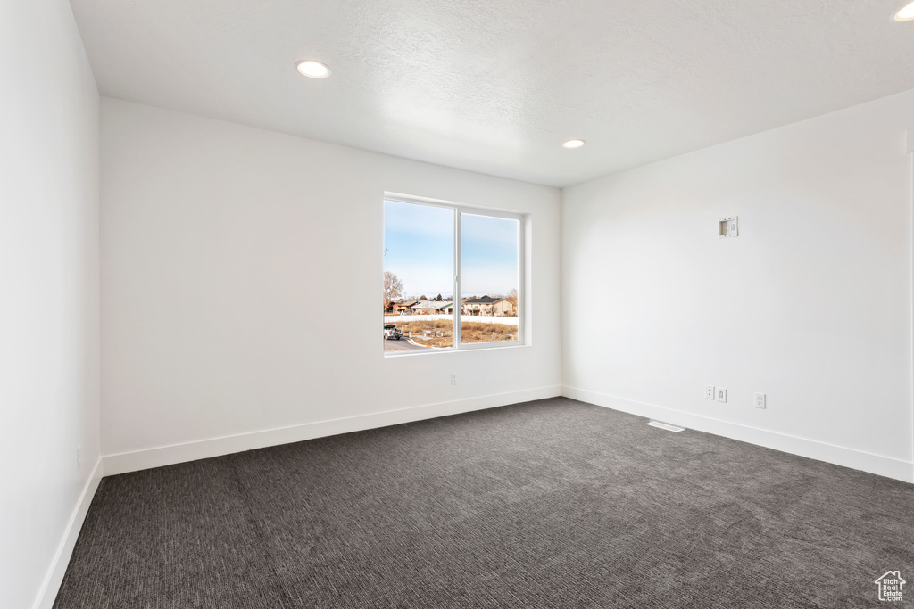 Unfurnished room featuring dark colored carpet, recessed lighting, and baseboards