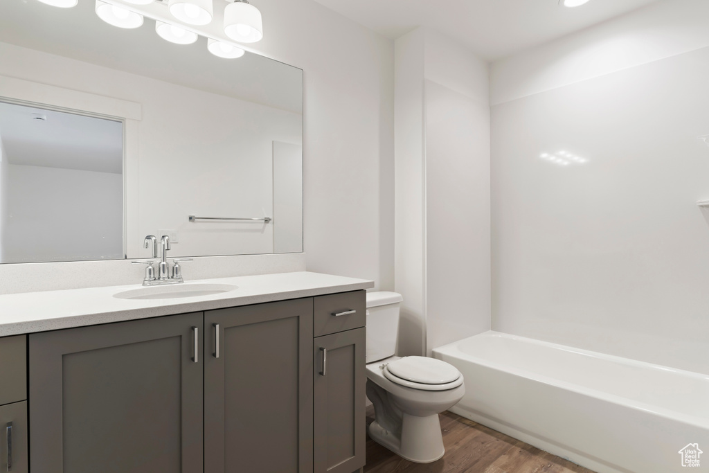 Full bath featuring wood finished floors, toilet, and vanity
