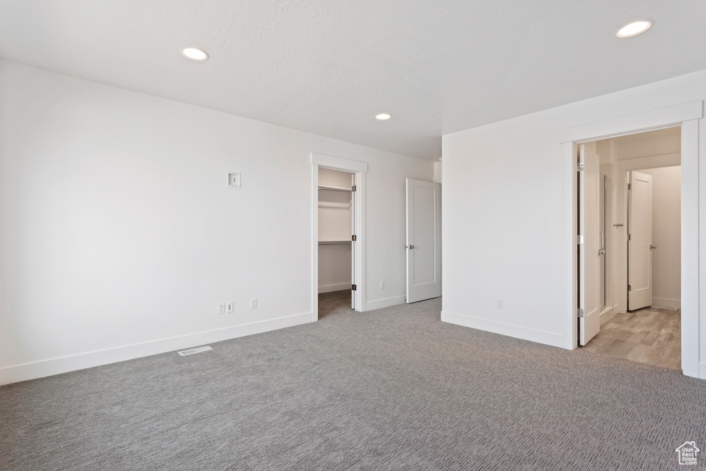 Unfurnished bedroom featuring recessed lighting, baseboards, a spacious closet, and carpet