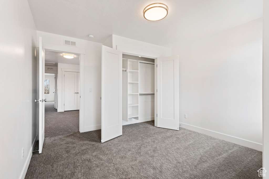 Unfurnished bedroom featuring carpet, baseboards, and a closet