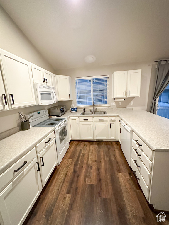Kitchen featuring white appliances, a sink, a peninsula, white cabinets, and light countertops