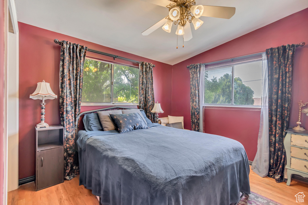 Bedroom featuring vaulted ceiling, wood finished floors, and ceiling fan