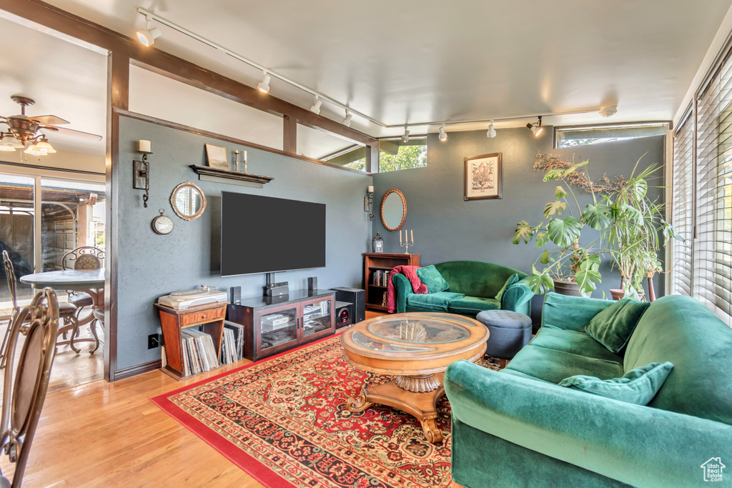 Living area with rail lighting, wood finished floors, and healthy amount of natural light