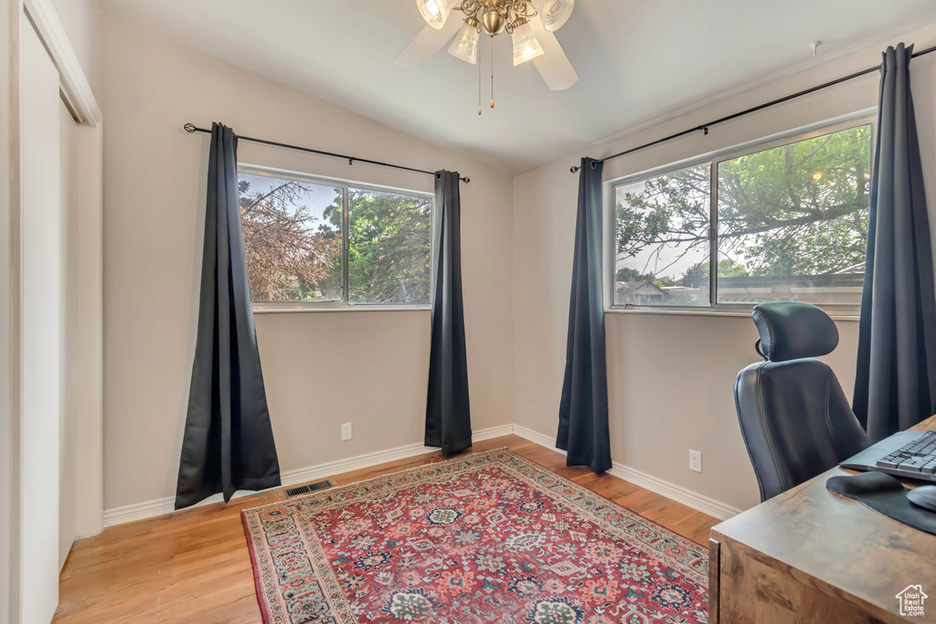 Home office with light wood-style floors, a ceiling fan, lofted ceiling, and baseboards