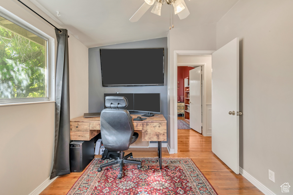 Office space featuring light wood-type flooring, a ceiling fan, lofted ceiling, and baseboards