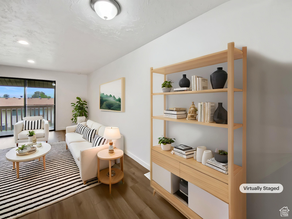 Living area with dark wood-type flooring, baseboards, and recessed lighting