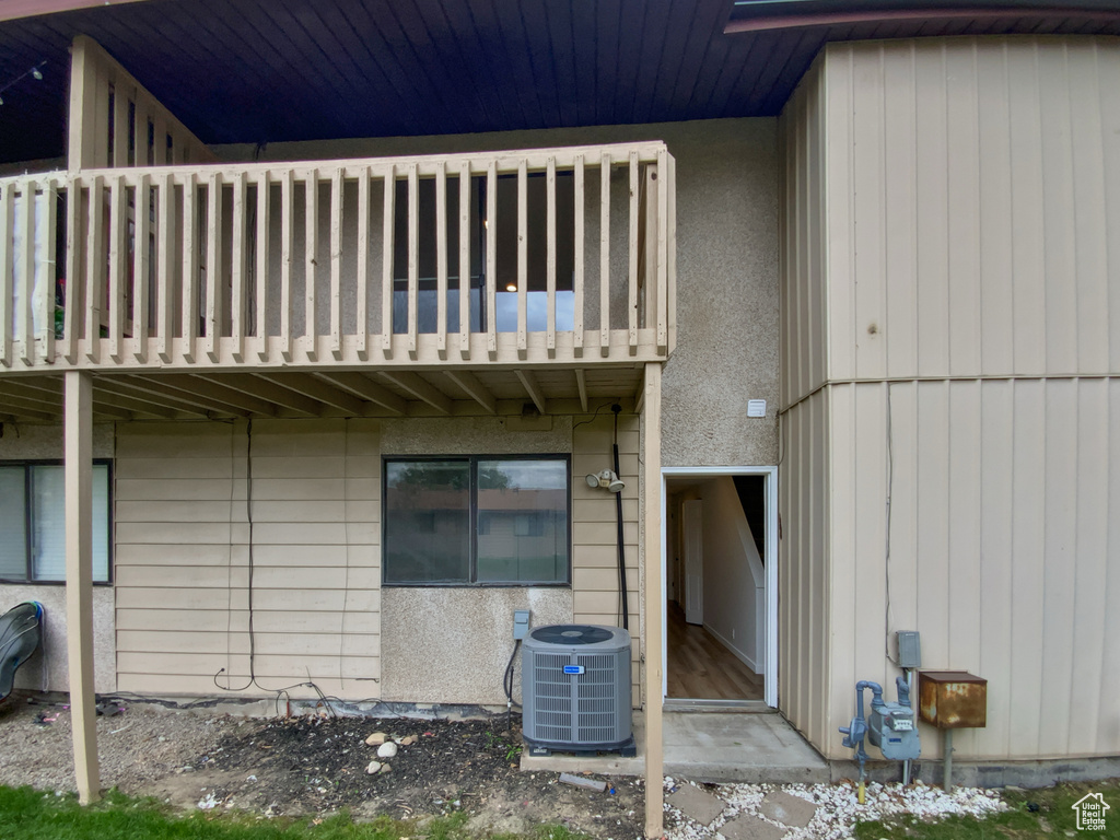 Back of property featuring a balcony and central AC unit