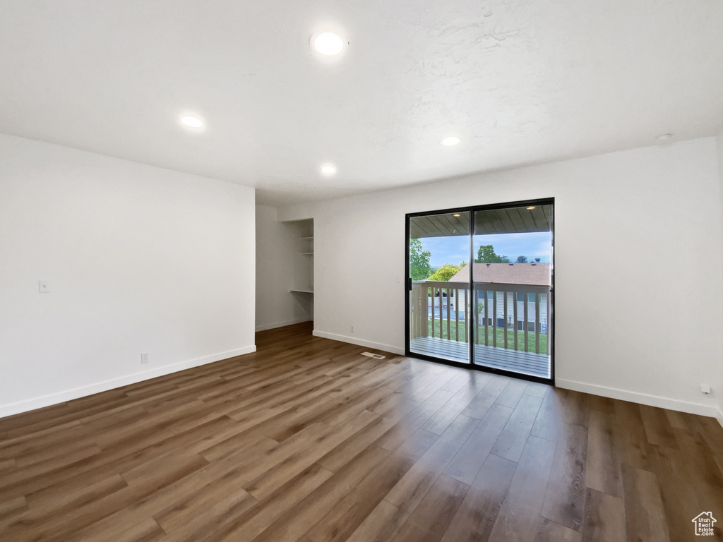 Unfurnished room with baseboards, wood finished floors, and recessed lighting