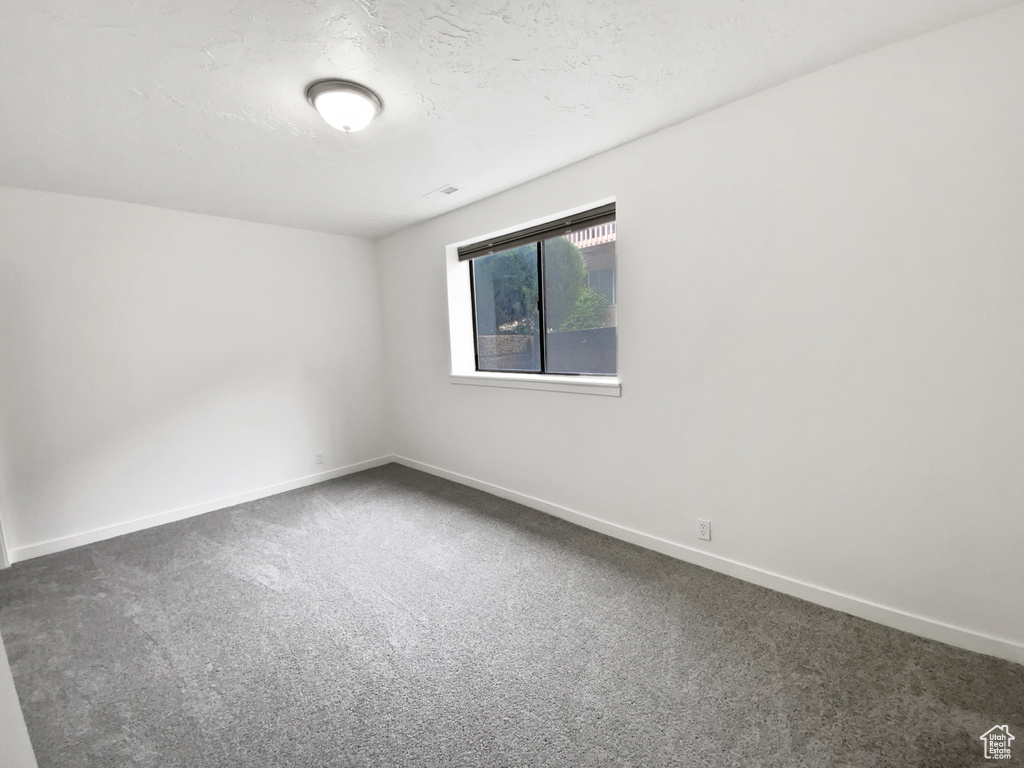 Carpeted empty room featuring baseboards