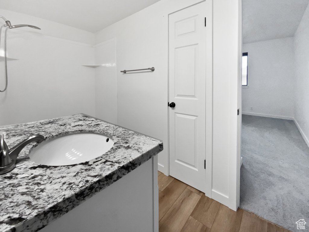 Bathroom with wood finished floors, baseboards, and vanity