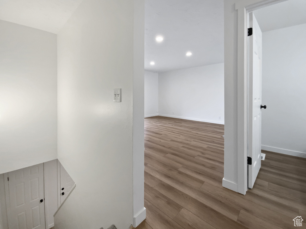 Corridor featuring wood finished floors, recessed lighting, and baseboards