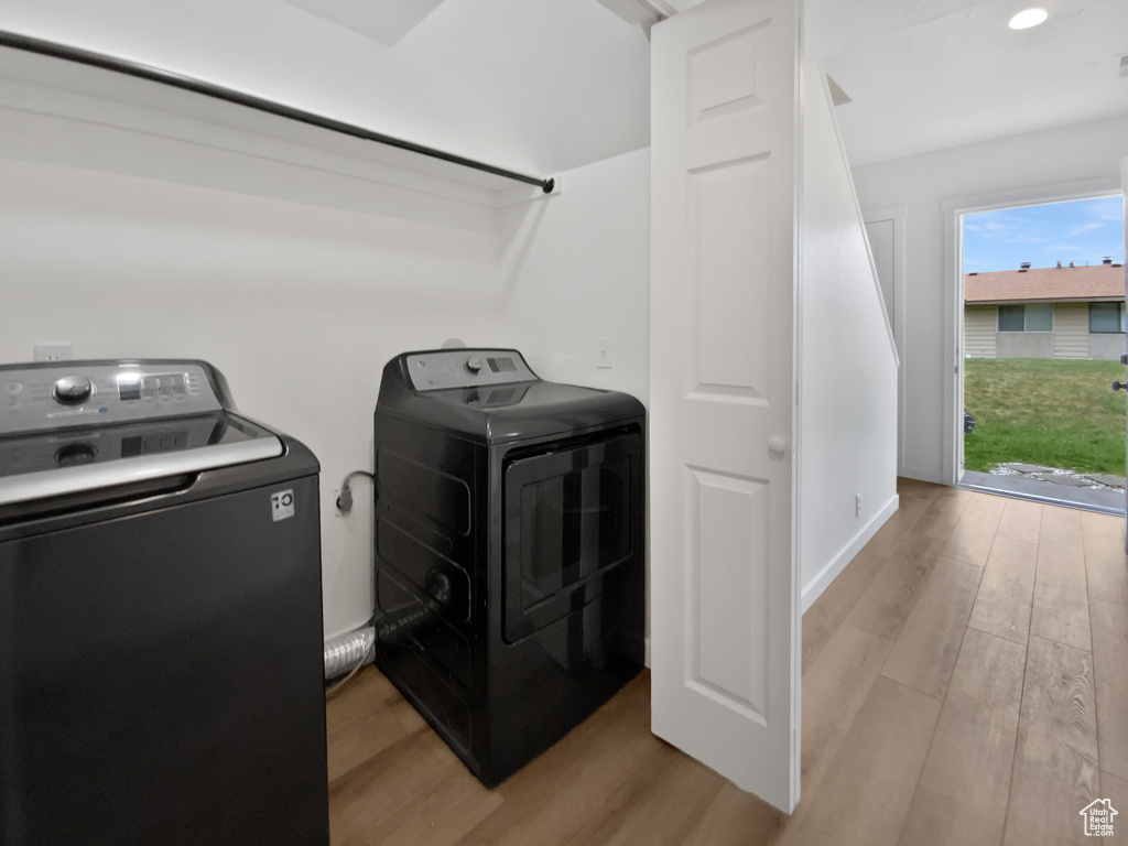 Laundry room featuring separate washer and dryer and light wood finished floors