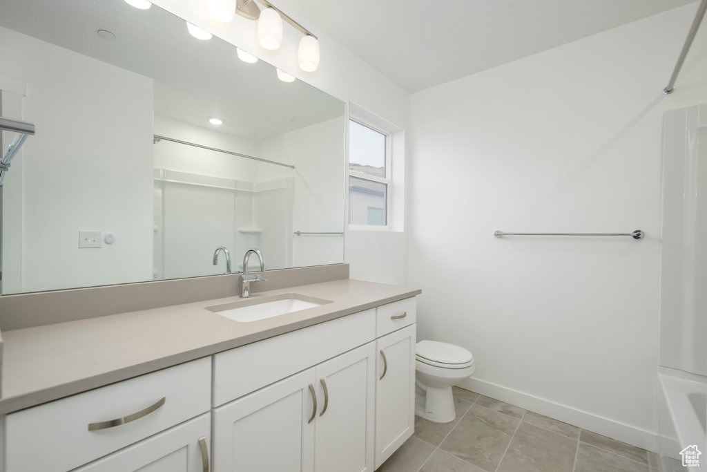 Full bath featuring baseboards, toilet, and vanity