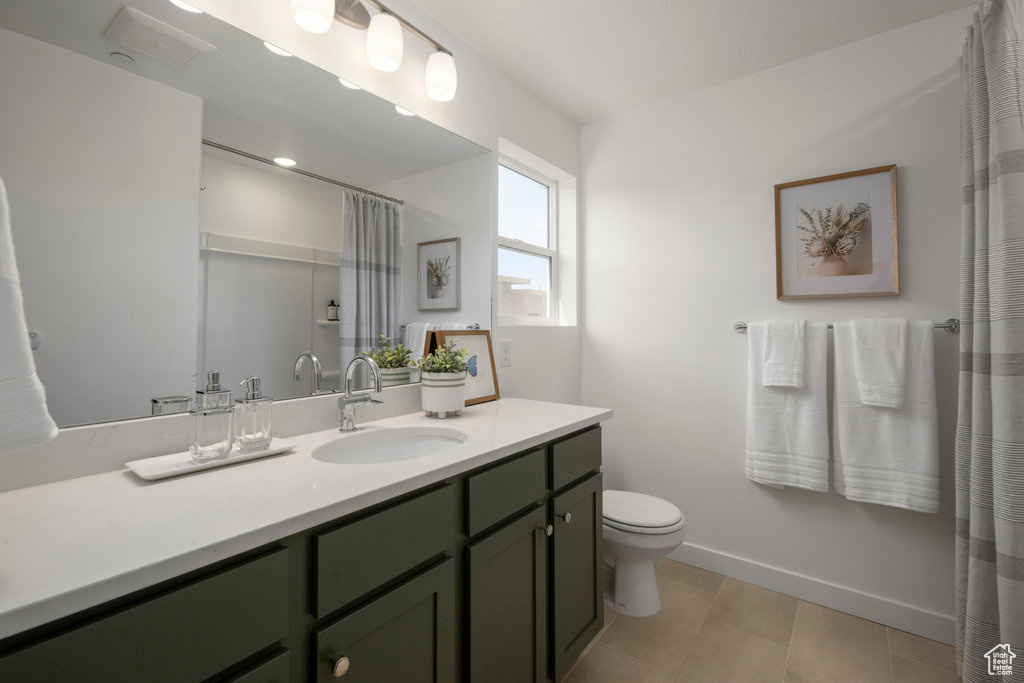 Full bath with toilet, baseboards, tile patterned floors, and vanity