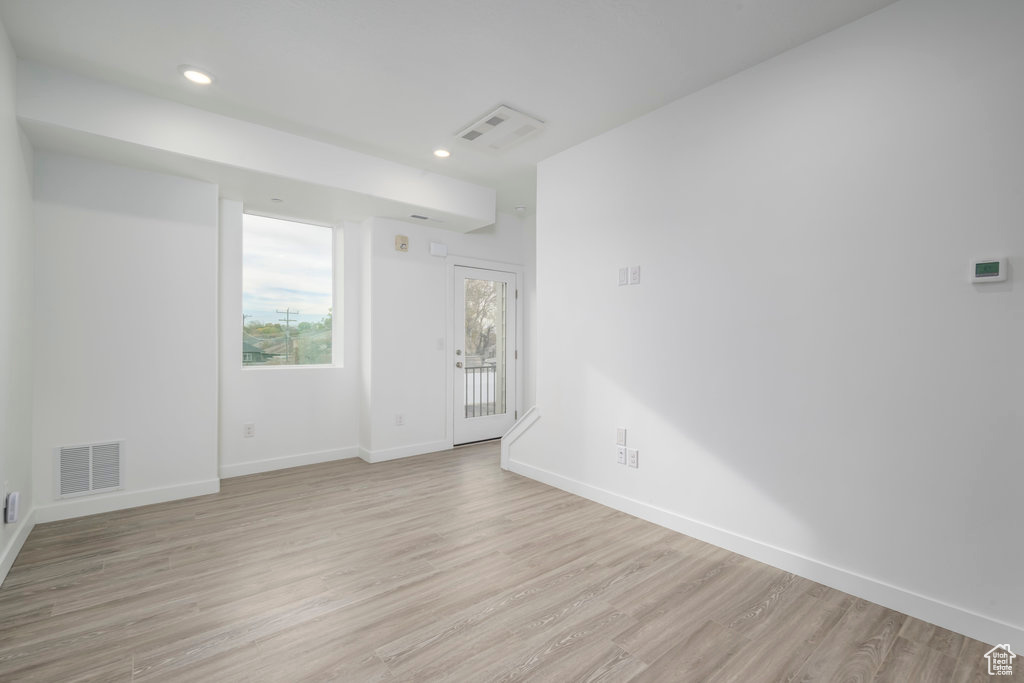 Empty room with light wood-type flooring, baseboards, and recessed lighting