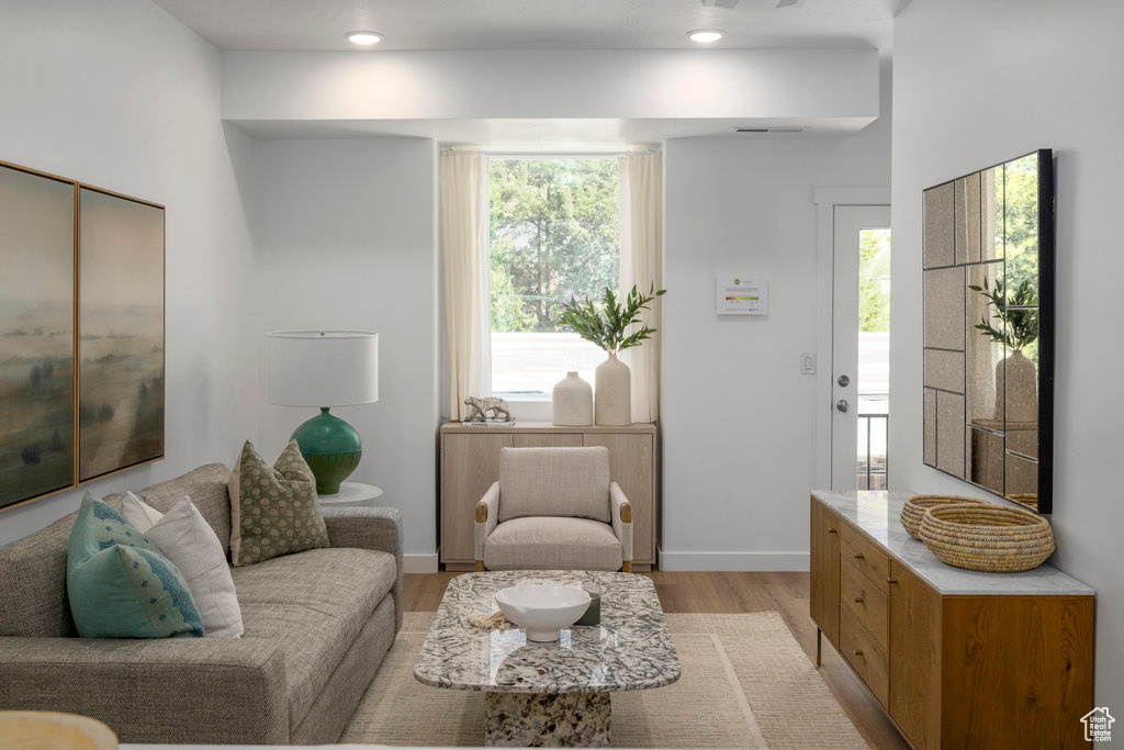 Living area featuring baseboards, light wood-style flooring, and visible vents