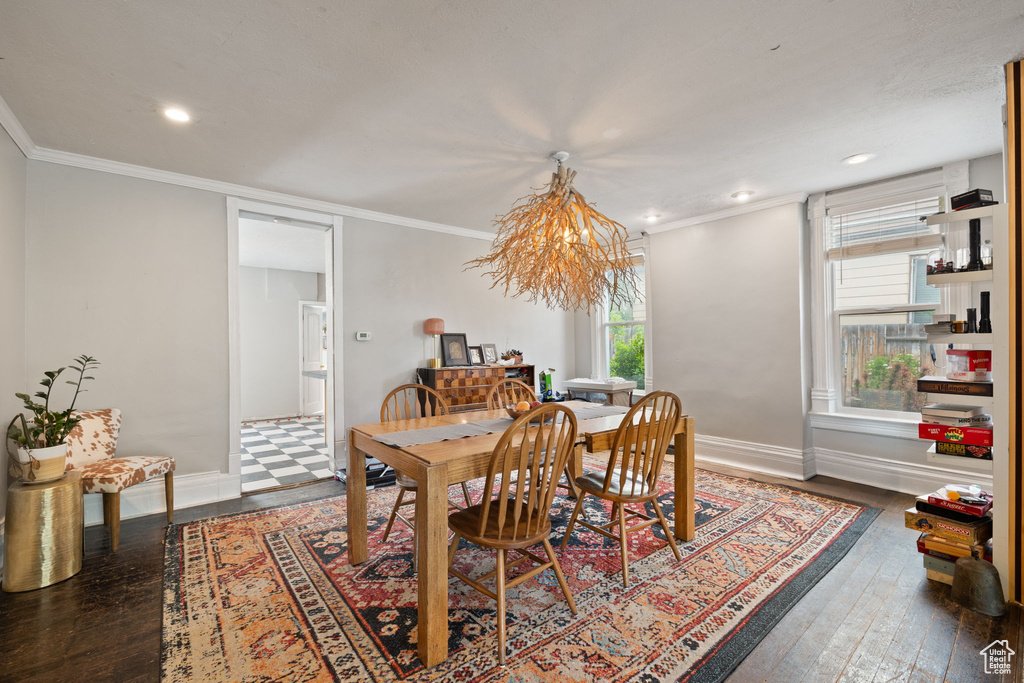 Dining room featuring a chandelier, wood-type flooring, ornamental molding, baseboards, and recessed lighting