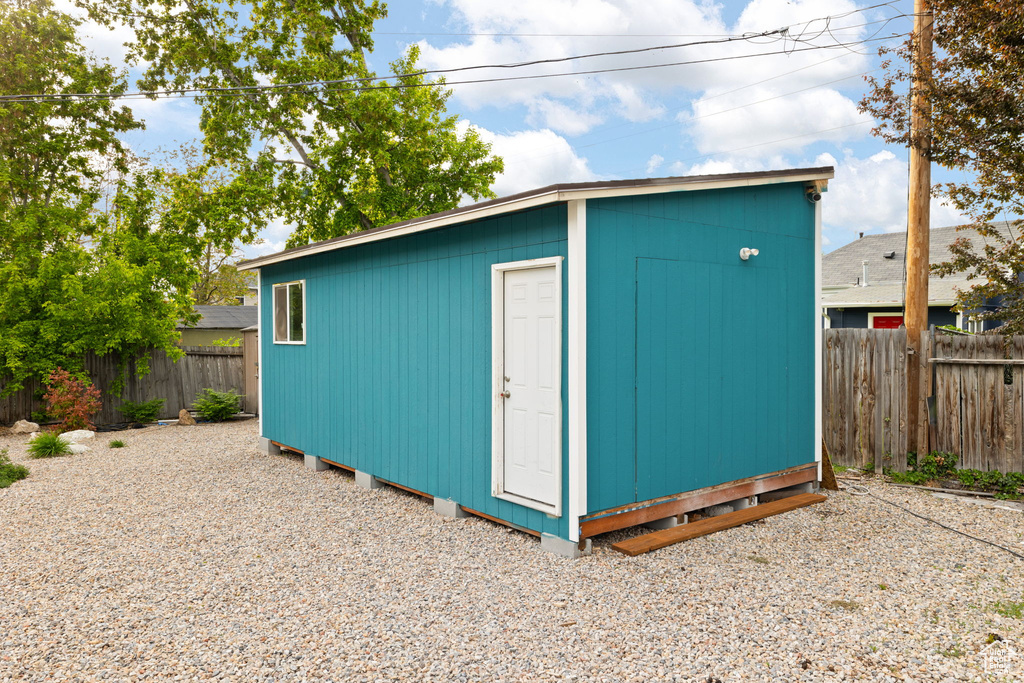 View of outdoor structure featuring a fenced backyard and an outbuilding