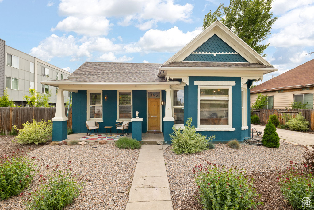 View of front of property featuring a porch and fence